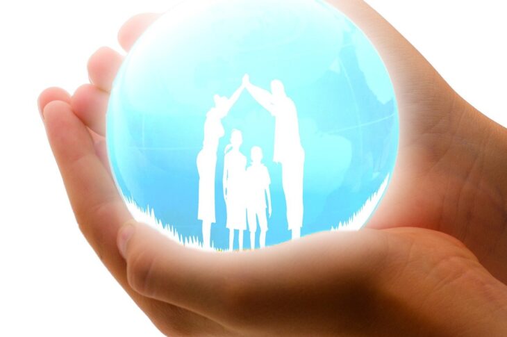 Mains tenant globe avec silhouette de famille