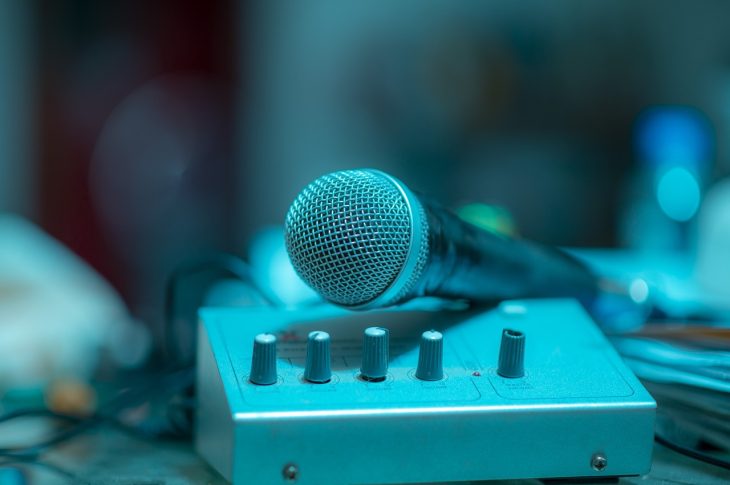 Microphone professionnel et mixeur audio sur table.