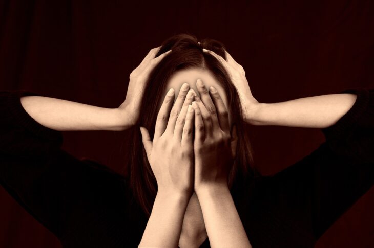 Femme stressée cachant son visage avec mains